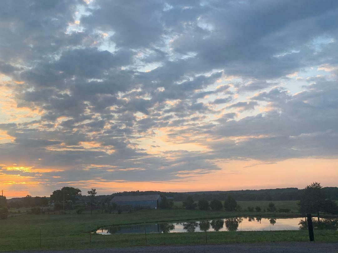 Sunset over the farm's fields, barn and pond at Center Ridge